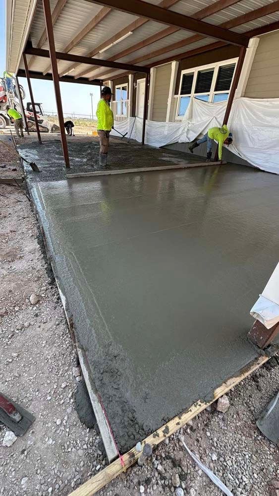 A group of construction workers are working on a concrete floor.