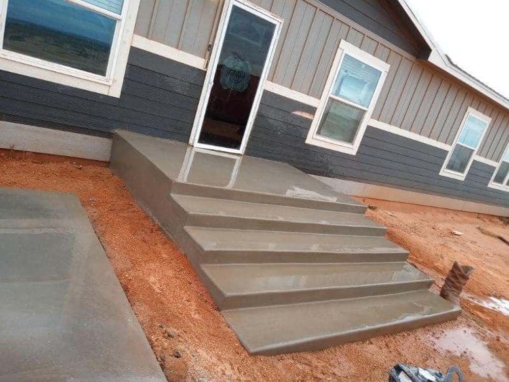 A house with concrete steps leading up to the front door.