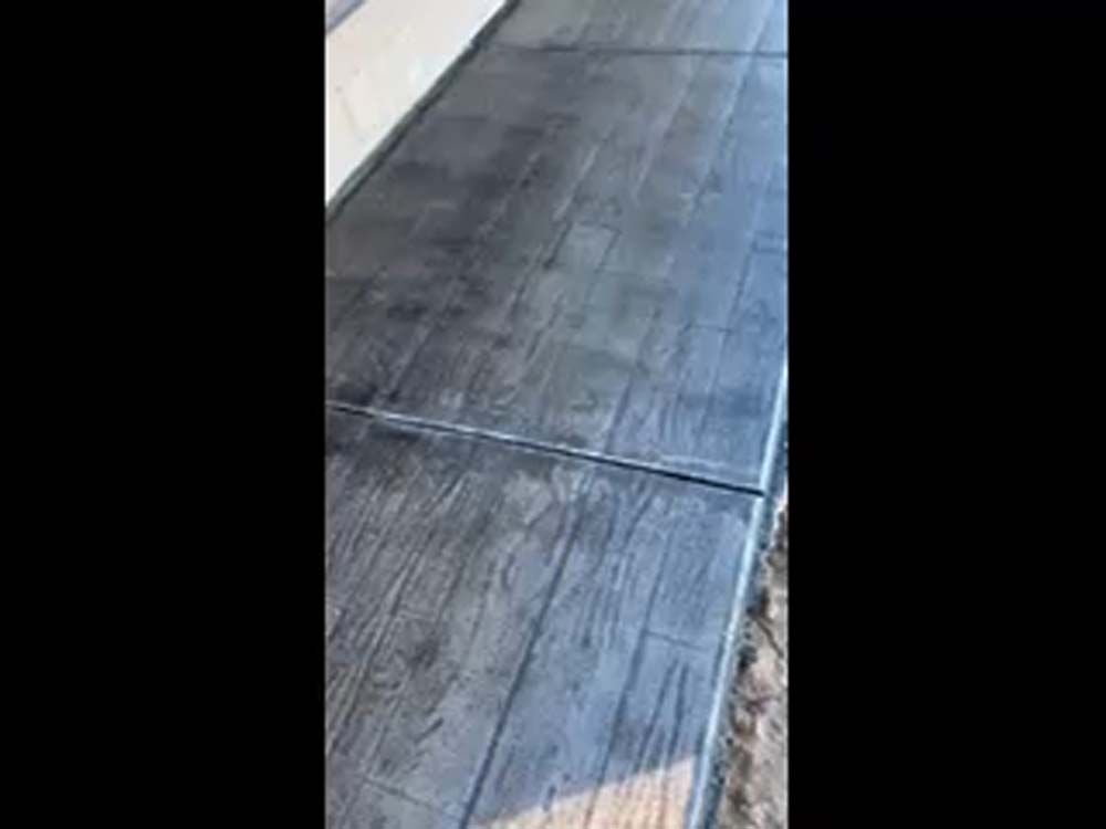 A concrete walkway that looks like wood is being built.
