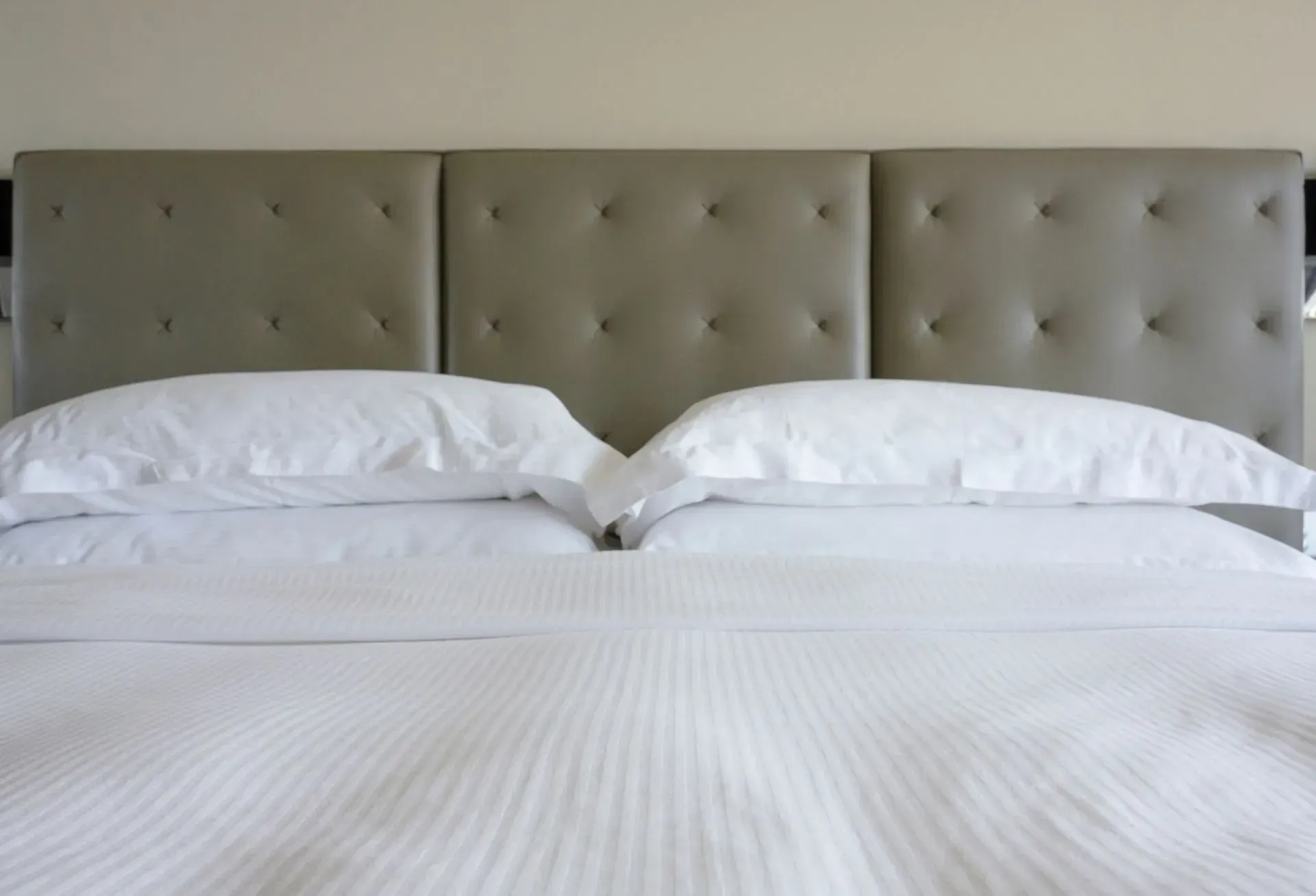 A Bed With White Sheets and Pillows in a Hotel Room — F.R.I. Foam & Rubber Industries In Gympie, QLD