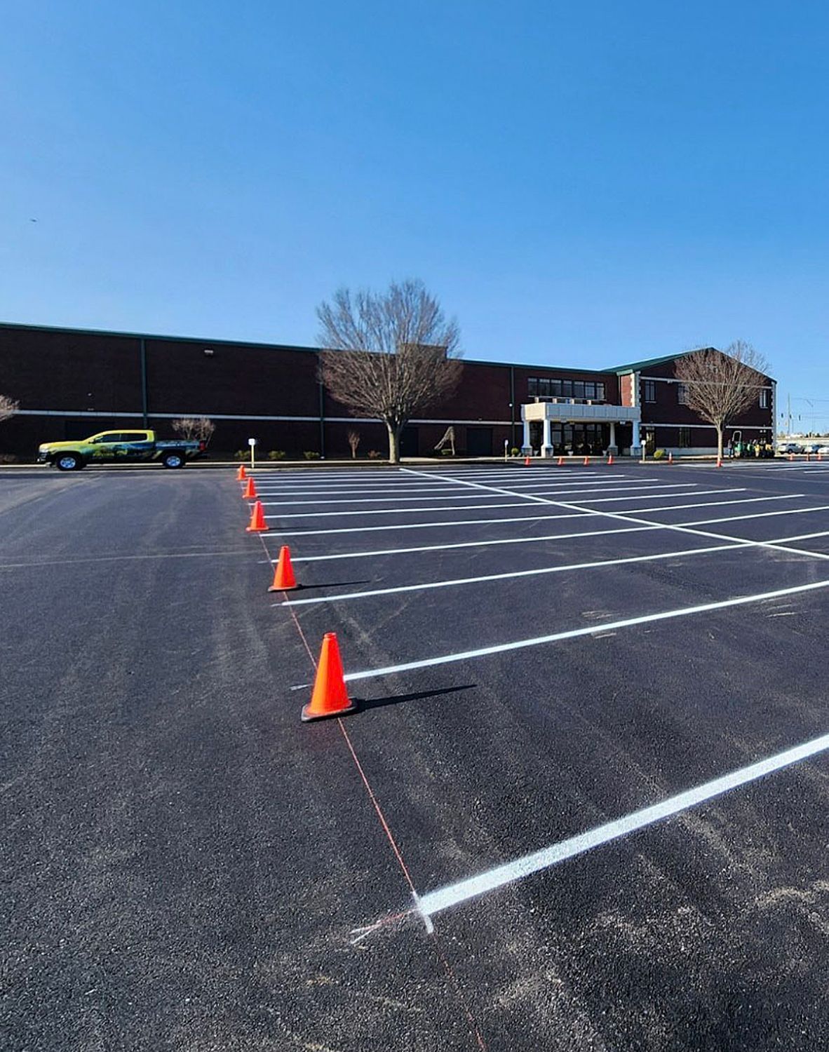 Glass doors in a modern building's facade reflect the surroundings, with palm trees visible.