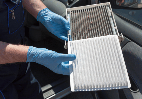 Technician holding a clean and dirty cabin air filter side by side