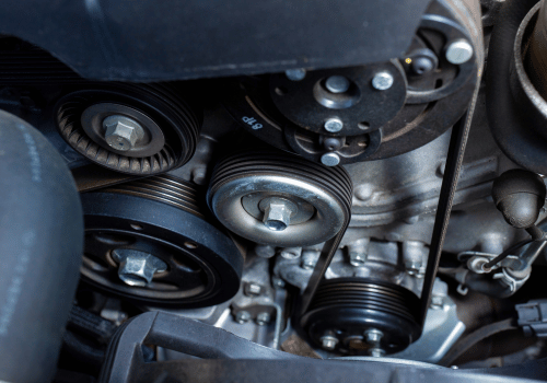 Close-up of engine serpentine belt and pulleys inside the engine bay