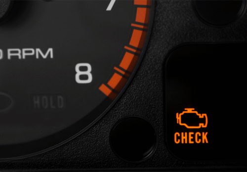 Dashboard close-up showing illuminated check engine warning light next to tachometer.