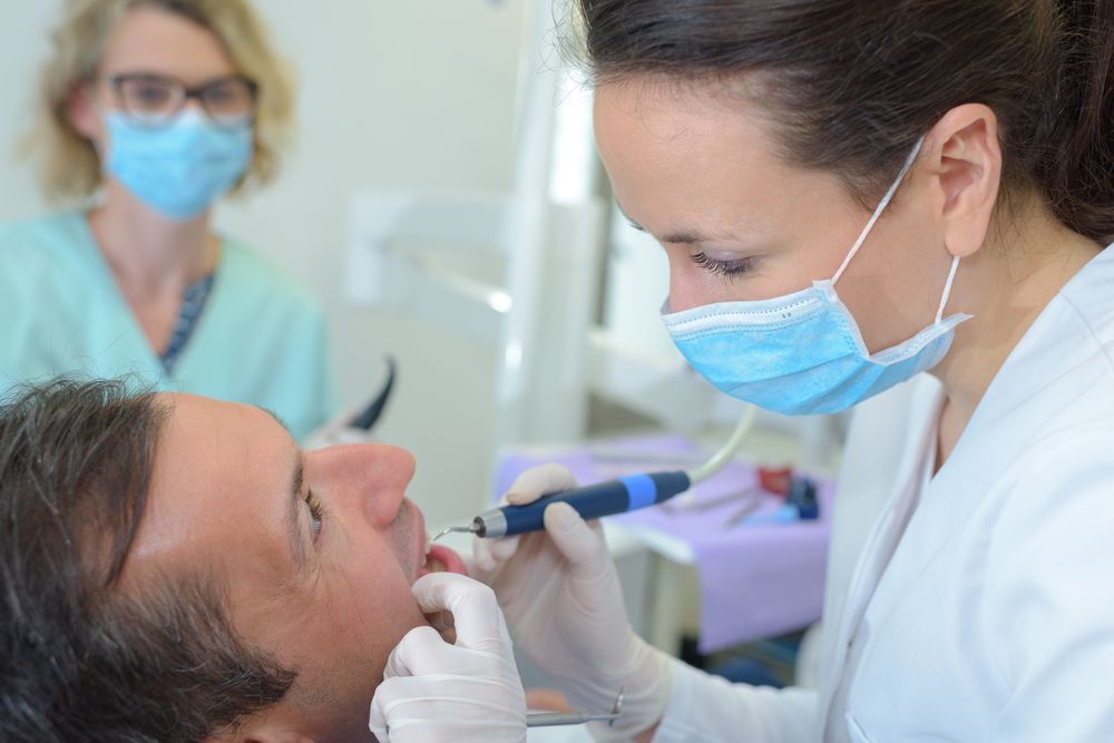 A female dentist is examining a teeth in a dental office.