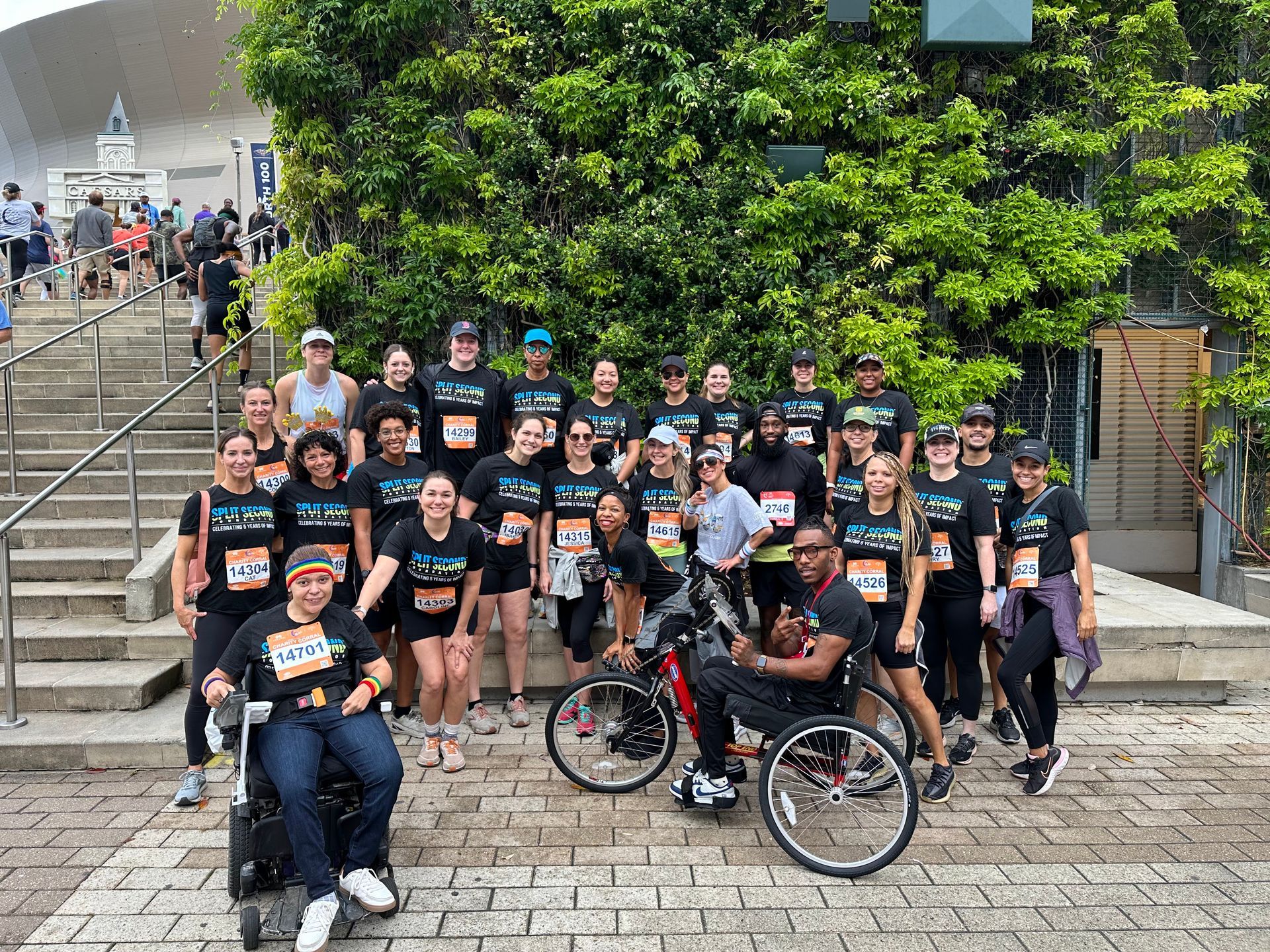 A group of people are posing for a picture with a man in a wheelchair.