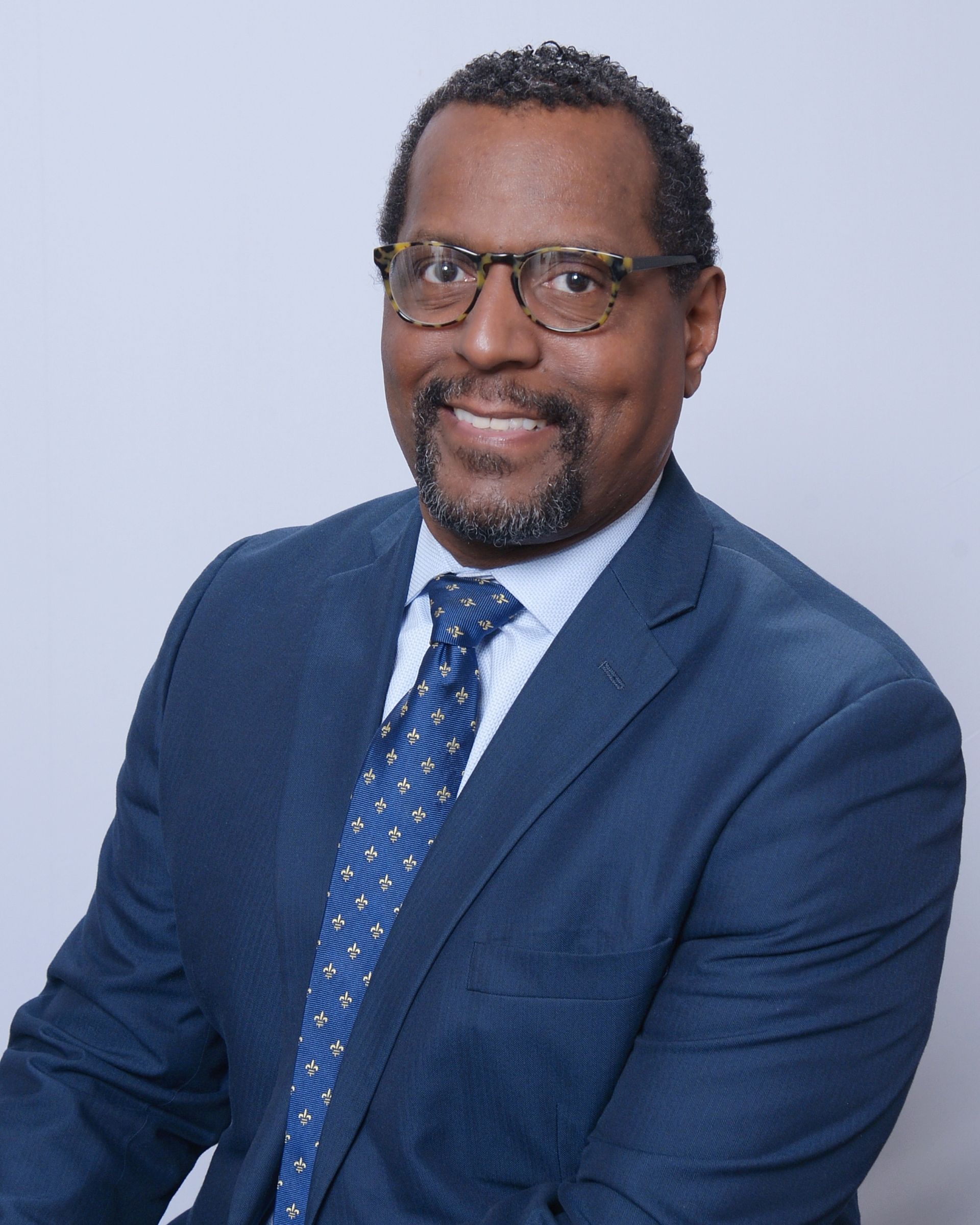 A man in a suit and tie is smiling for the camera.