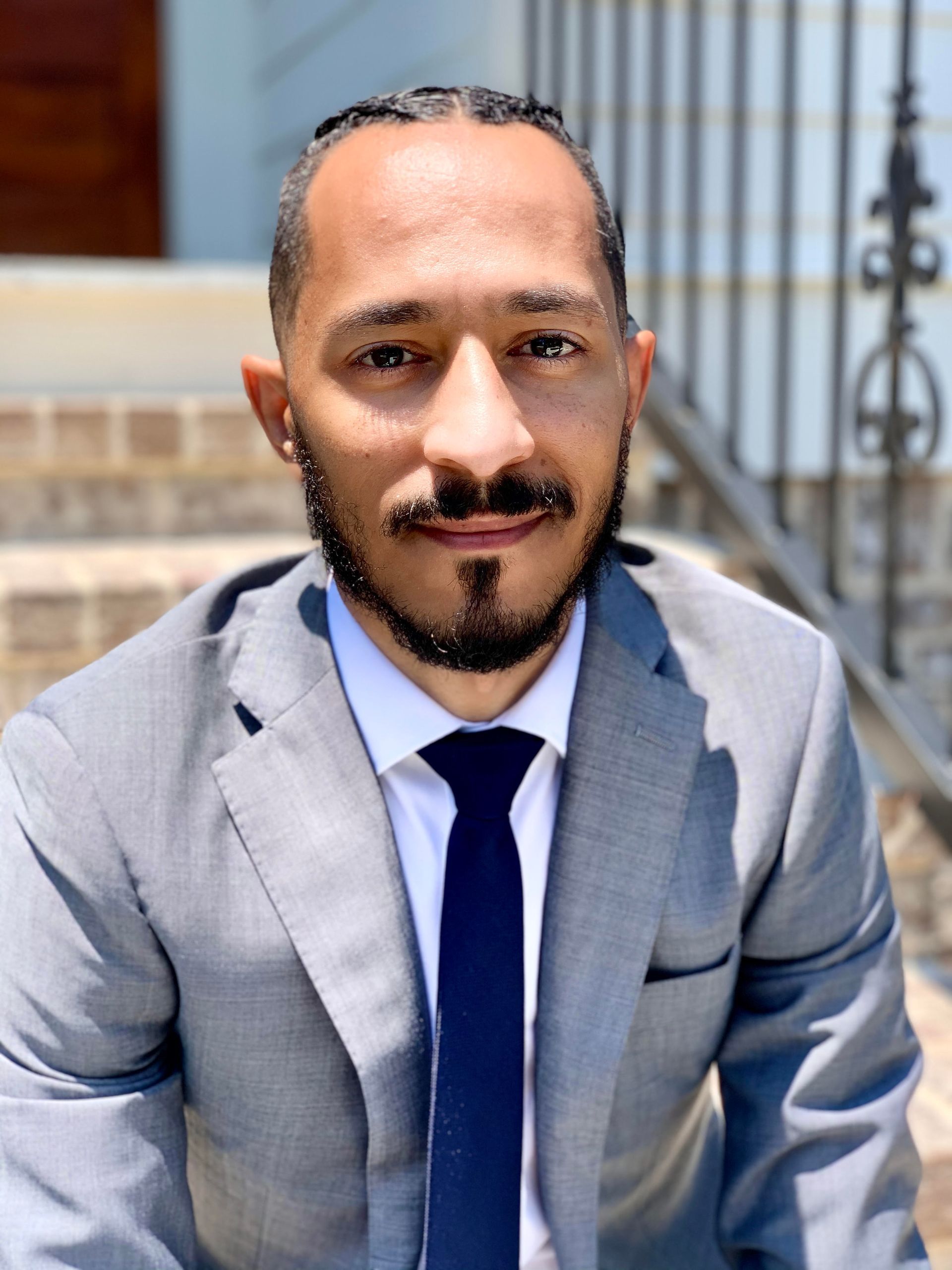 A man with a beard is wearing a suit and tie