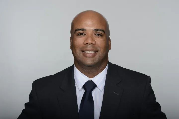 A man in a suit and tie is smiling for the camera