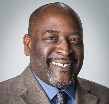 A man in a suit and tie is smiling for the camera.