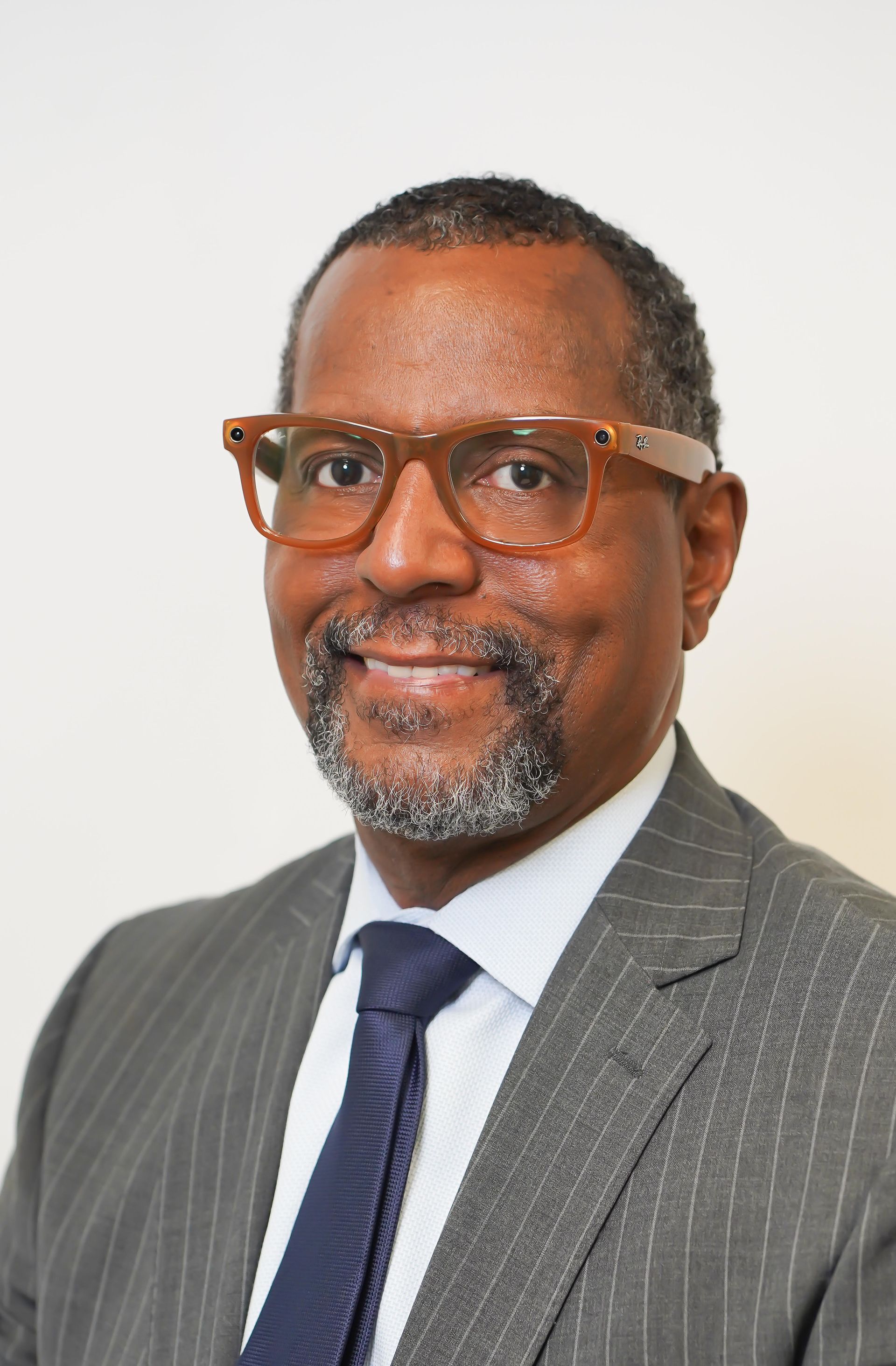 A man in a suit and tie is smiling for the camera.