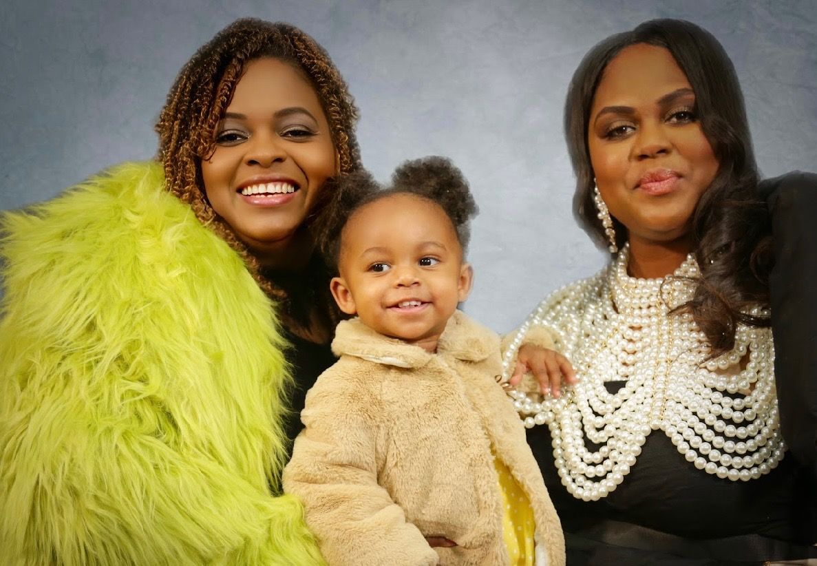 A group of women posing for a picture with feathers around their necks