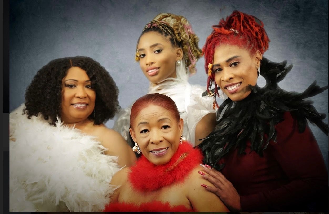 A group of women posing for a picture with feathers around their necks