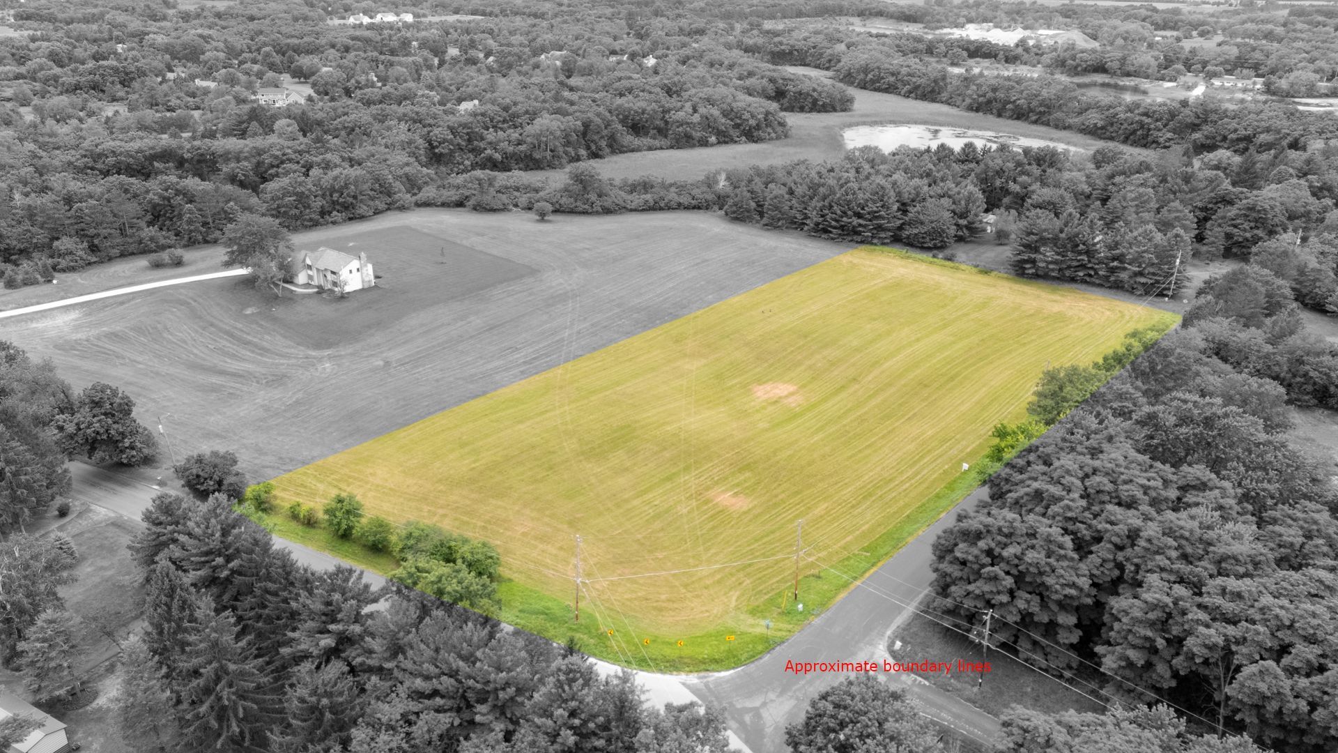 An aerial view of a large field surrounded by trees.