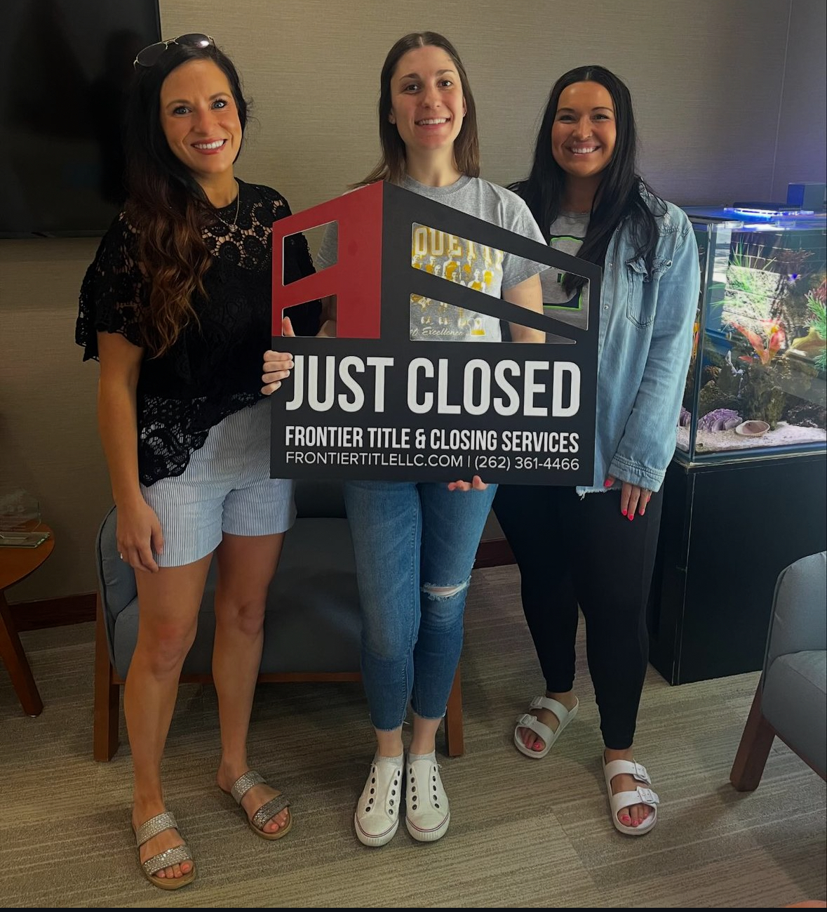 Three women are standing next to each other holding a sign that says just closed.
