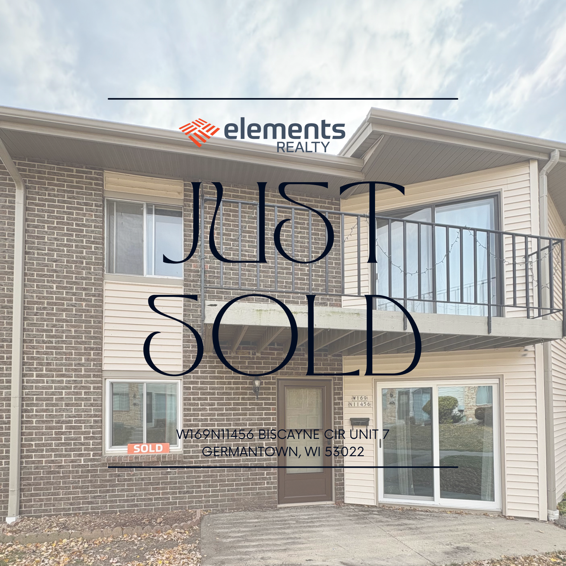 A large apartment building with a sidewalk and trees in front of it.