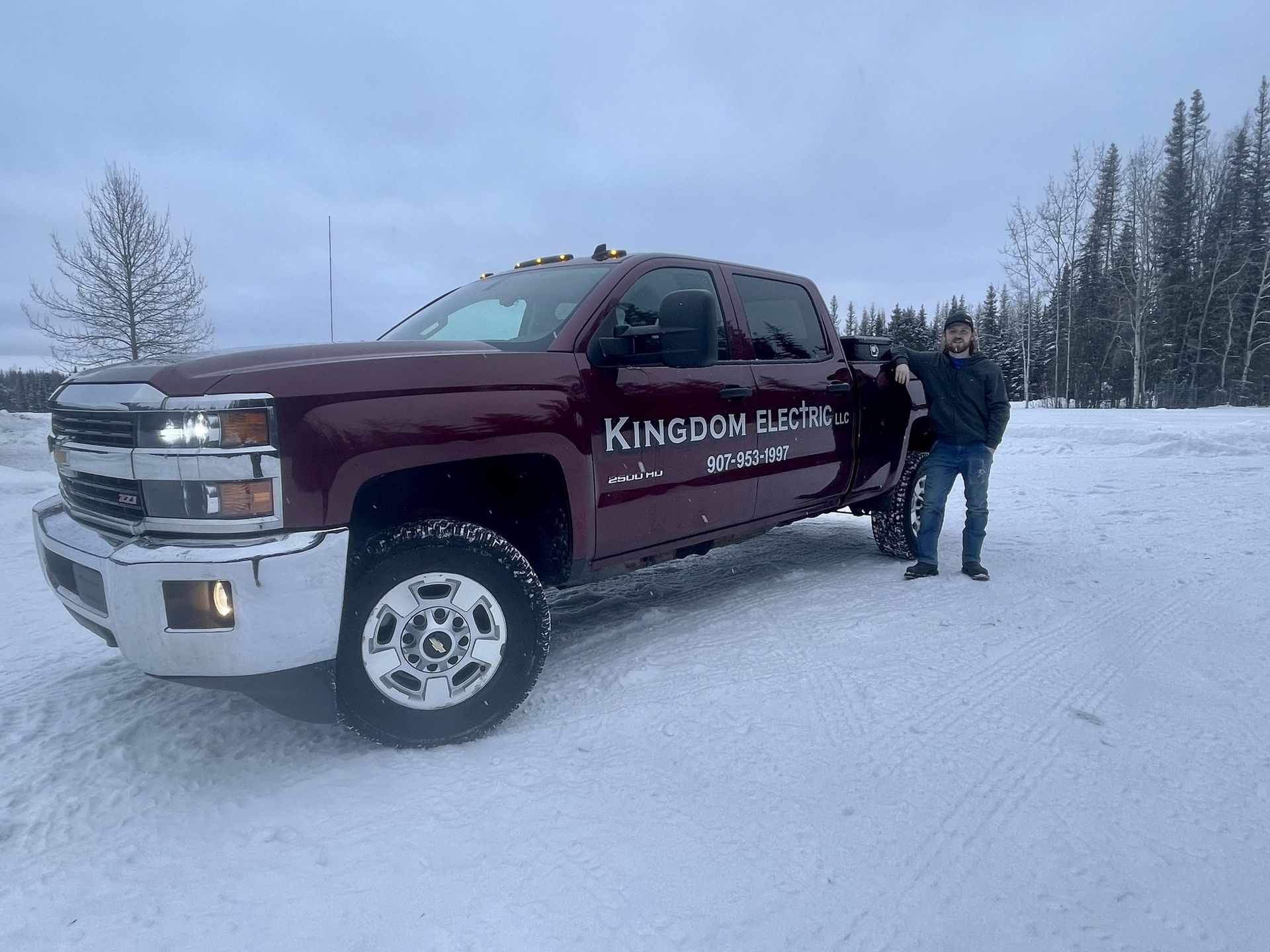 Man standing beside maroon truck with 