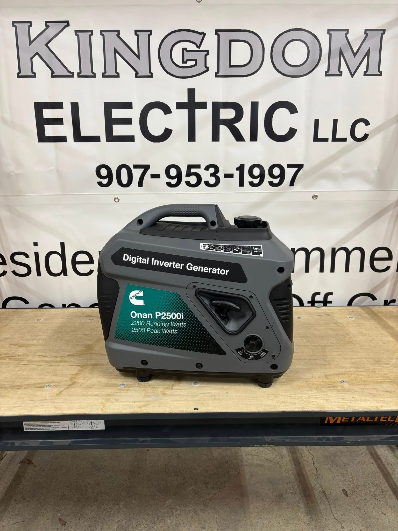 A gray and teal Cummins generator on a wooden surface, with 