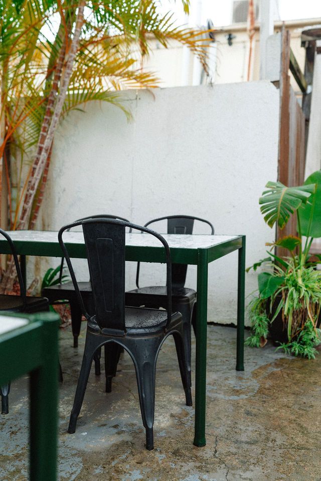 A patio with a table and chairs in front of a white wall.