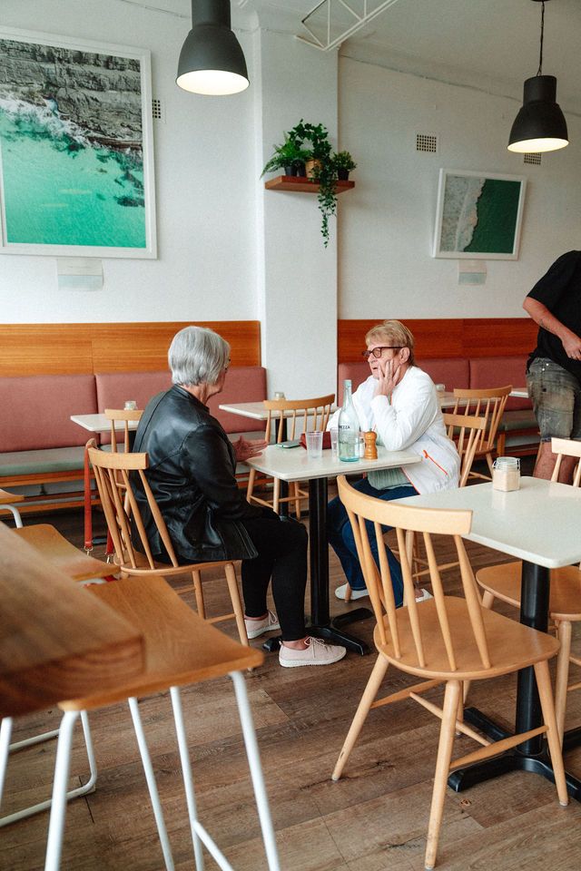 A group of people are sitting at tables in a restaurant.