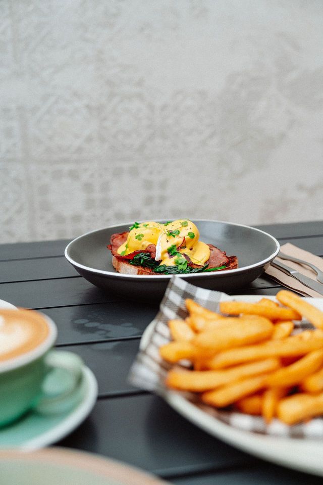 A table topped with plates of food and a cup of coffee.