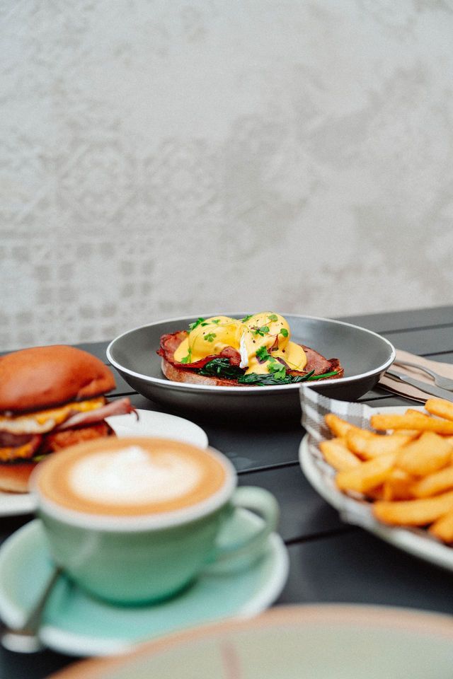 A table topped with plates of food and a cup of coffee.
