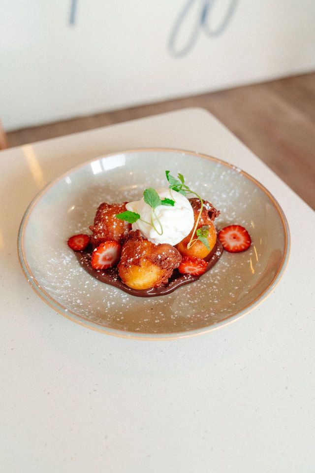A plate of food with strawberries and ice cream on a table.