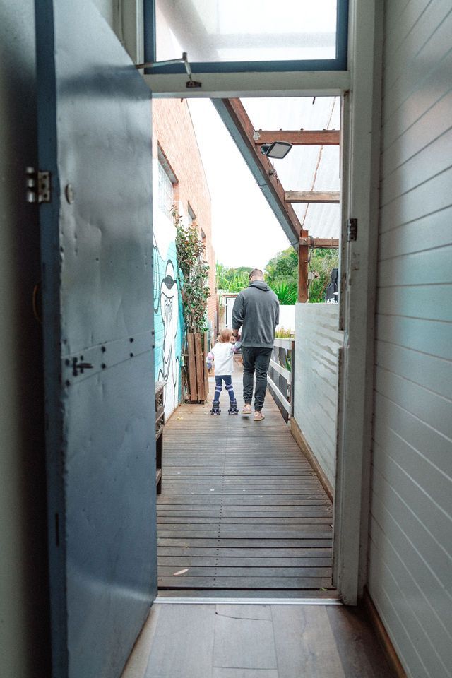 A man and a child are walking down a wooden walkway.