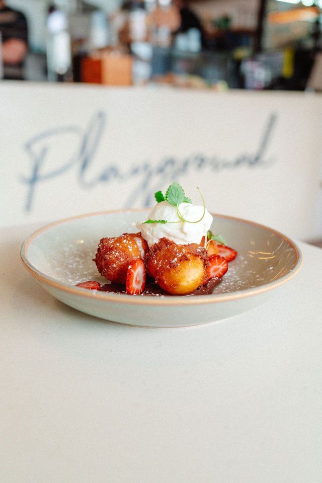 A plate of food with strawberries and whipped cream on a table.