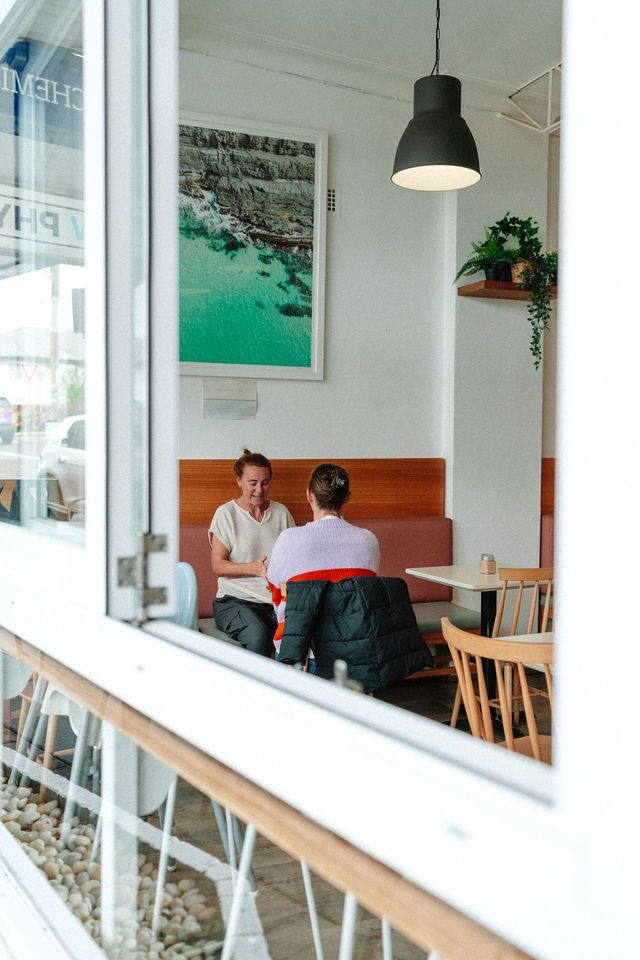 A couple of people are sitting at a table in a restaurant.