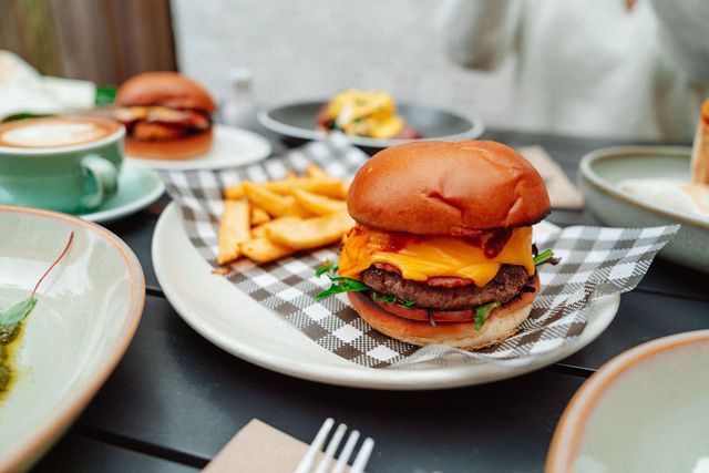A hamburger and french fries on a plate on a table.