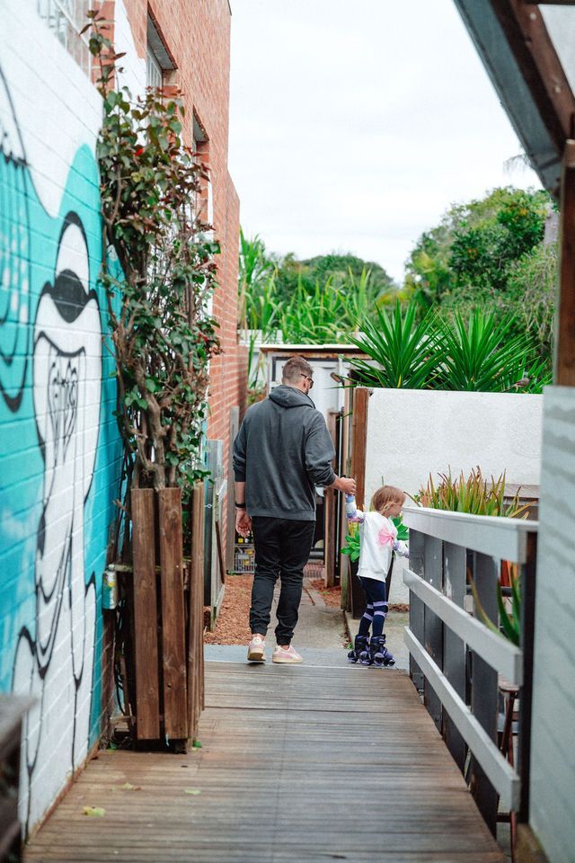 A man and a child are walking down a wooden walkway.
