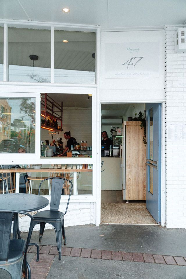 A restaurant with a table and chairs outside of it.