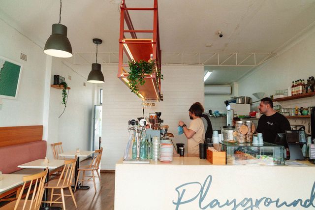 A restaurant with tables and chairs and a sign that says playground.