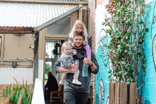 A man is carrying two children on his shoulders.
