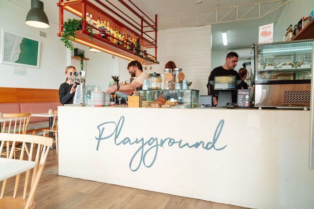 A group of people standing behind a counter in a restaurant.