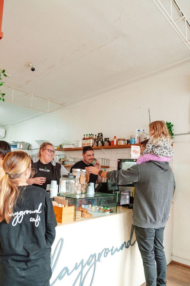 A group of people are standing around a counter in a restaurant.
