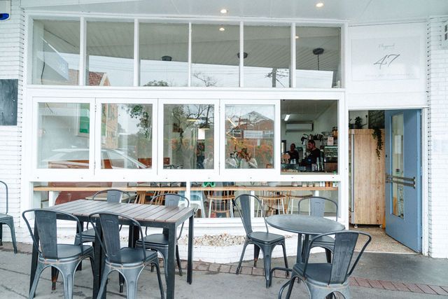 A restaurant with tables and chairs outside of it