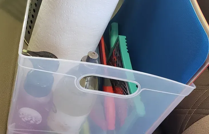A clear plastic bin filled with various items including a paper towel