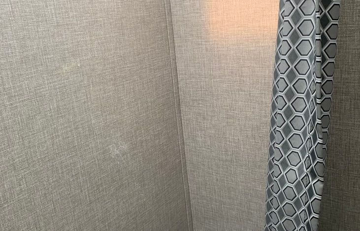 A shower curtain is hanging on a wall in a bathroom.