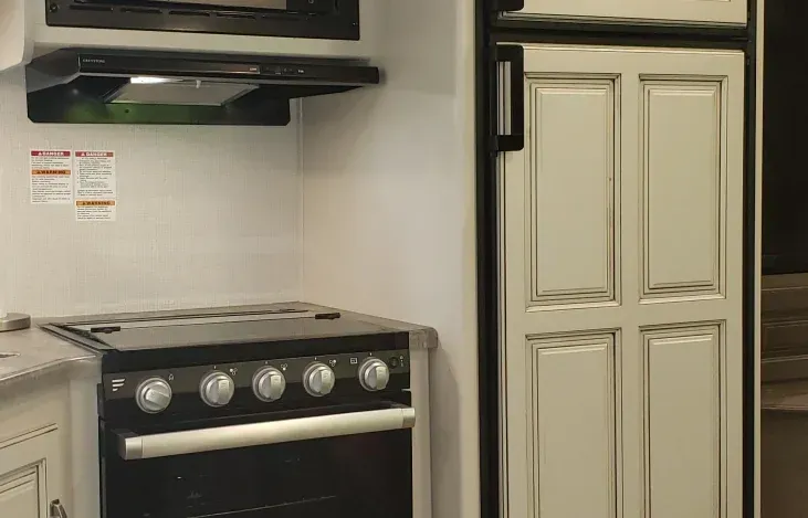 a kitchen with a stove , oven , refrigerator and microwave .