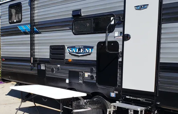 A rv with a table attached to the side of it.