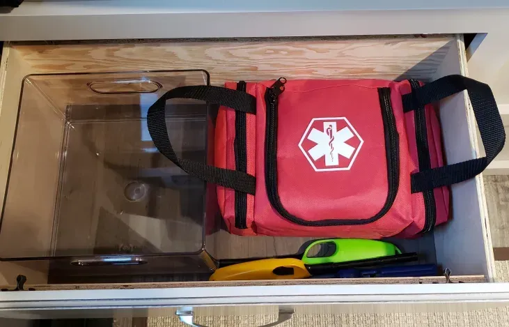 a red first aid kit is sitting in a drawer .