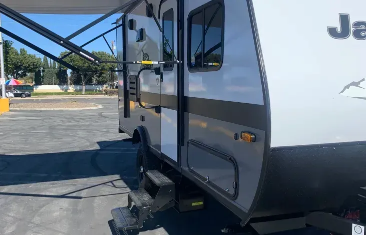A jeep trailer is parked in a parking lot.