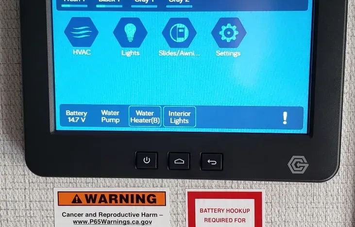 a warning sign is next to a thermostat on a wall .