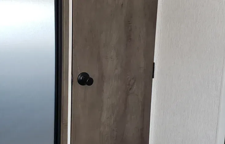 A close up of a wooden door with a black handle.