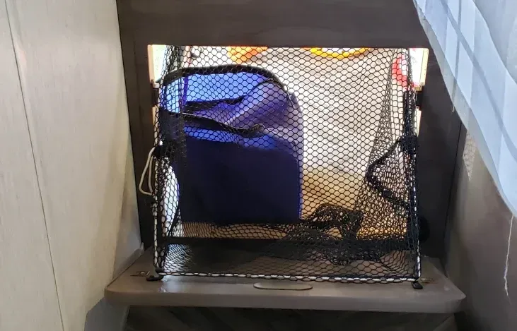 A blue bag is sitting in a mesh container on a table.