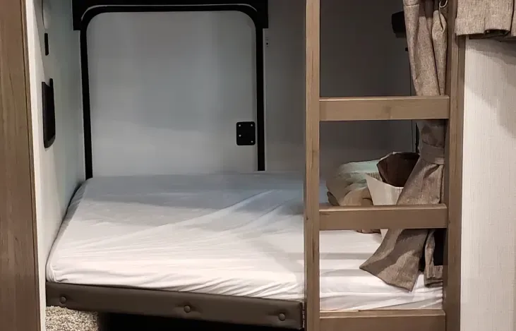 there is a bunk bed in the corner of the room .