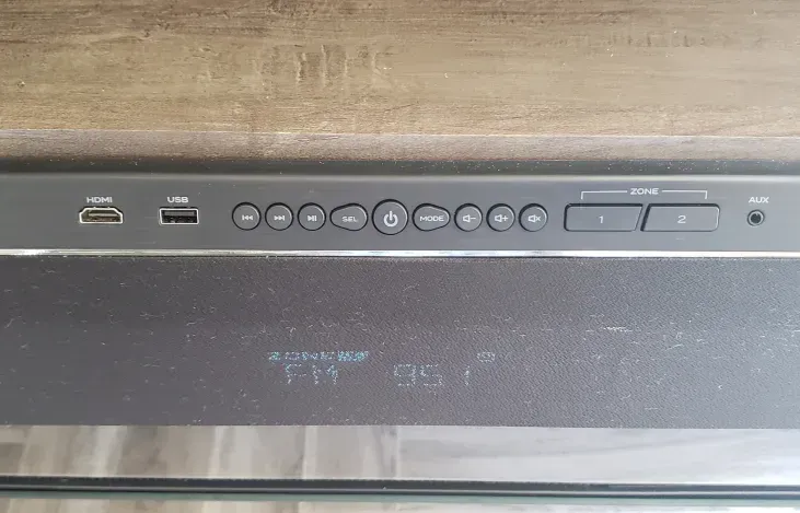 A close up of a remote control on a wooden table.