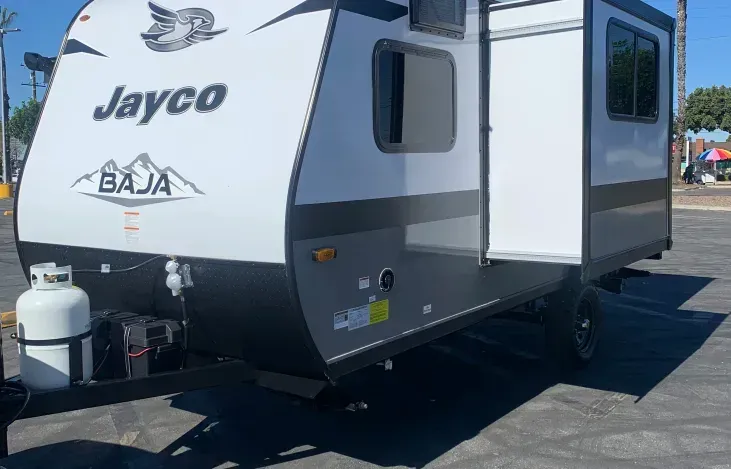 A jayco baja trailer is parked in a parking lot.